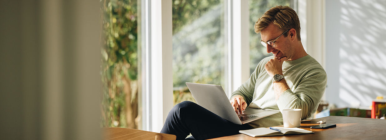 Mann zu Hause mit Laptop