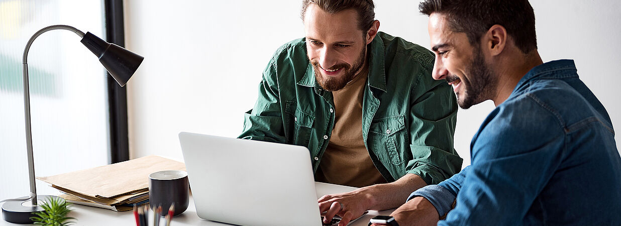 Mieter und Vermieter prüfen Betriebskostenabrechnung am Laptop